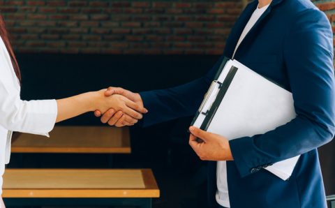 Business partners shaking hands after signing the contract.