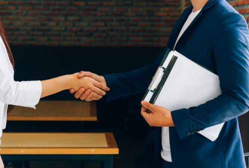 Business partners shaking hands after signing the contract.